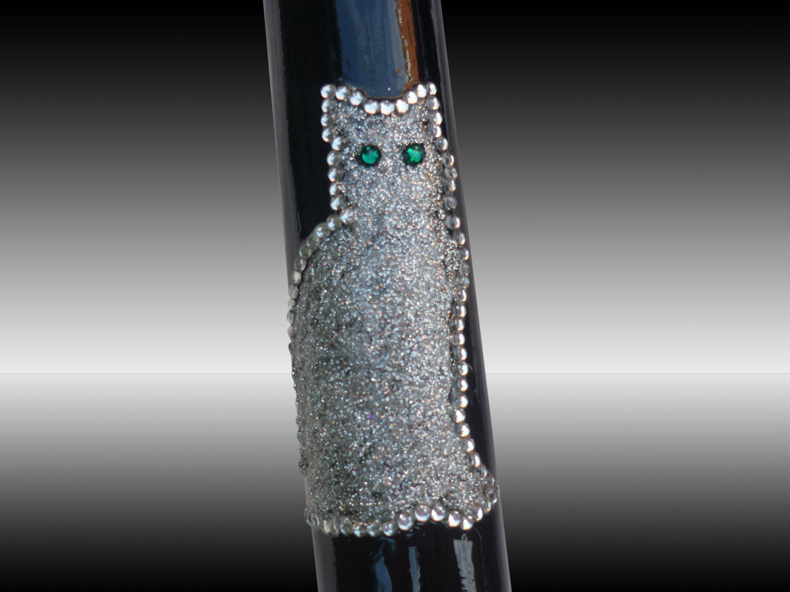 an image of the cat on the Crutch. Its outline is done by diamanté with the design inside smaller smaller diamanté. The eyes are green diamantés