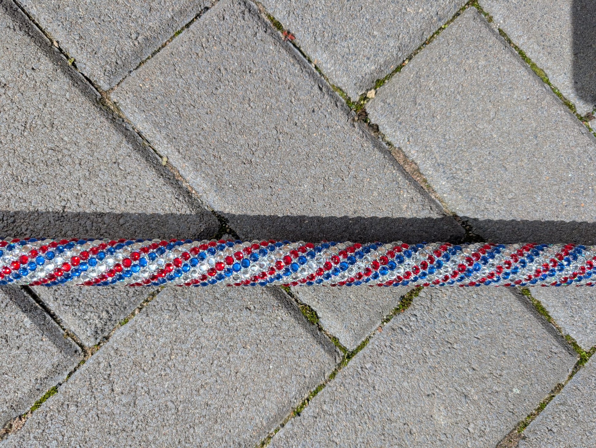 Red, white, and blue spiral stick on a concrete surface