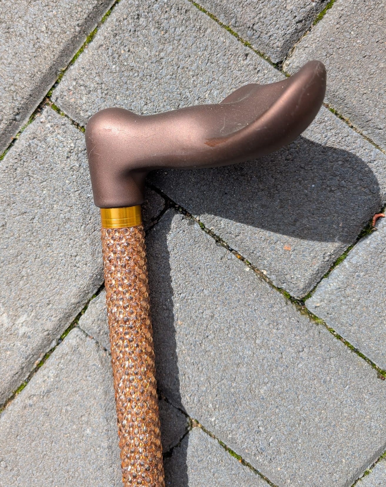 Cane with bronze handle on a paved surface