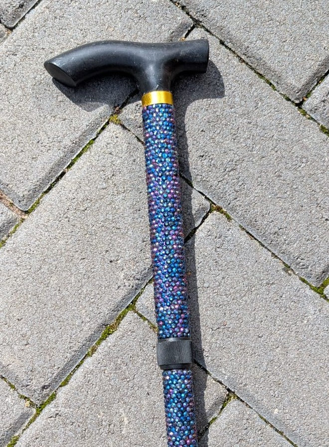 Cane with standard black handle on a paved surface