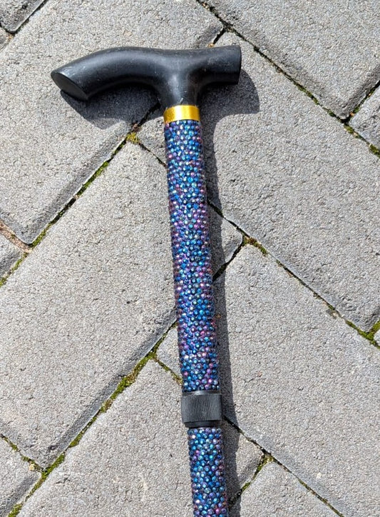 Cane with standard black handle on a paved surface