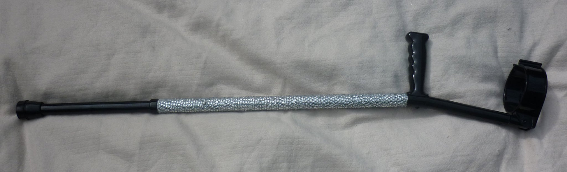 A close up of Diamonds Are A Girl’s Best Friend Crutch showing the clear diamanté. The handle and cuff are in black.
