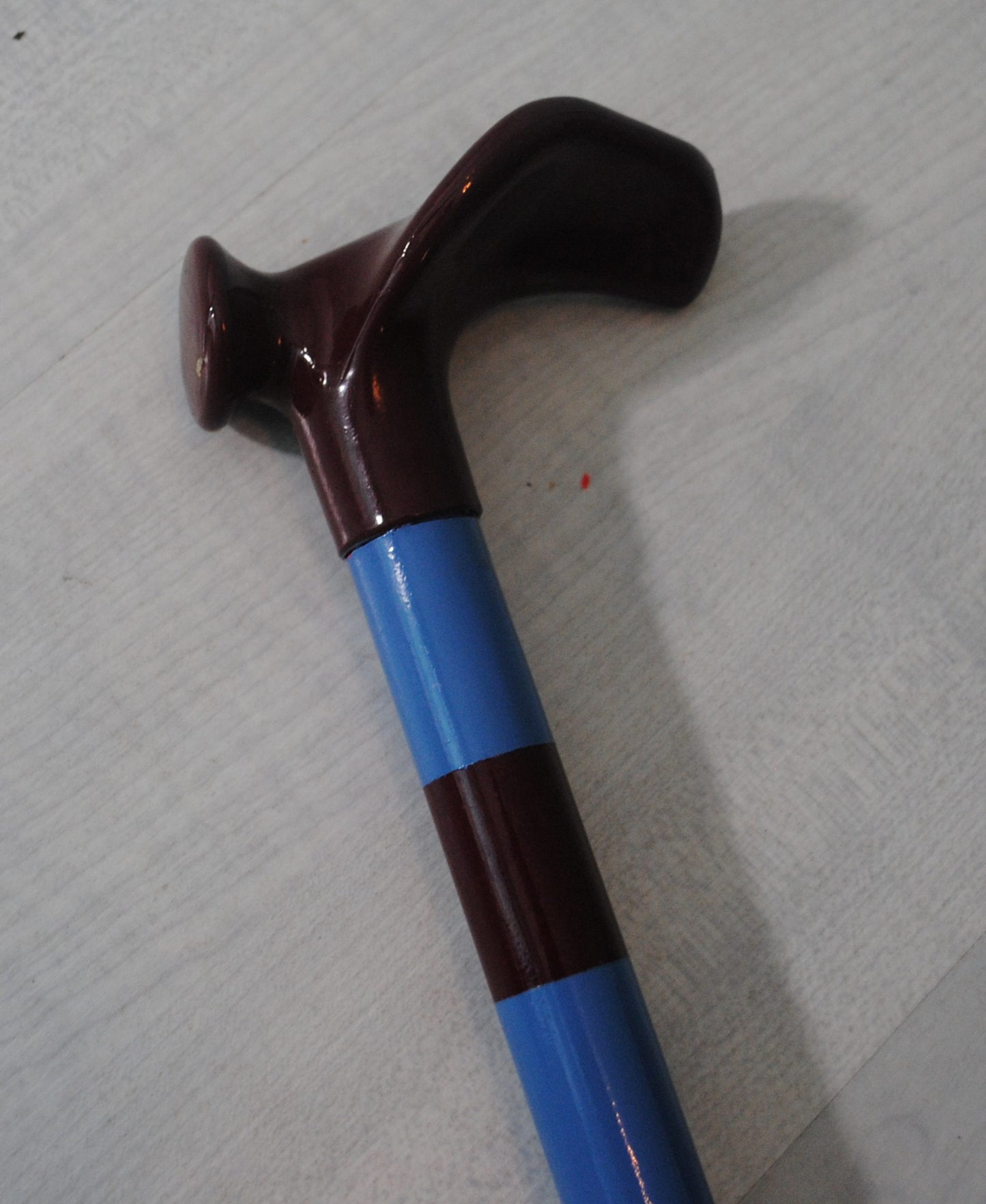 The handle of the Football Crazy Walking Stick in black, with the top of the stick in black and blue stripes