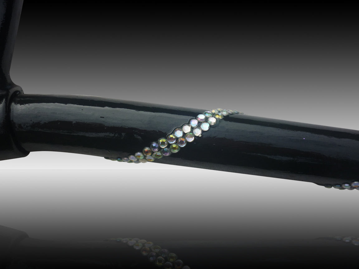 A close up of the Helenix Crutch in black with a row of white diamantés that shine different colours. The diamantés row roll down the crutch
