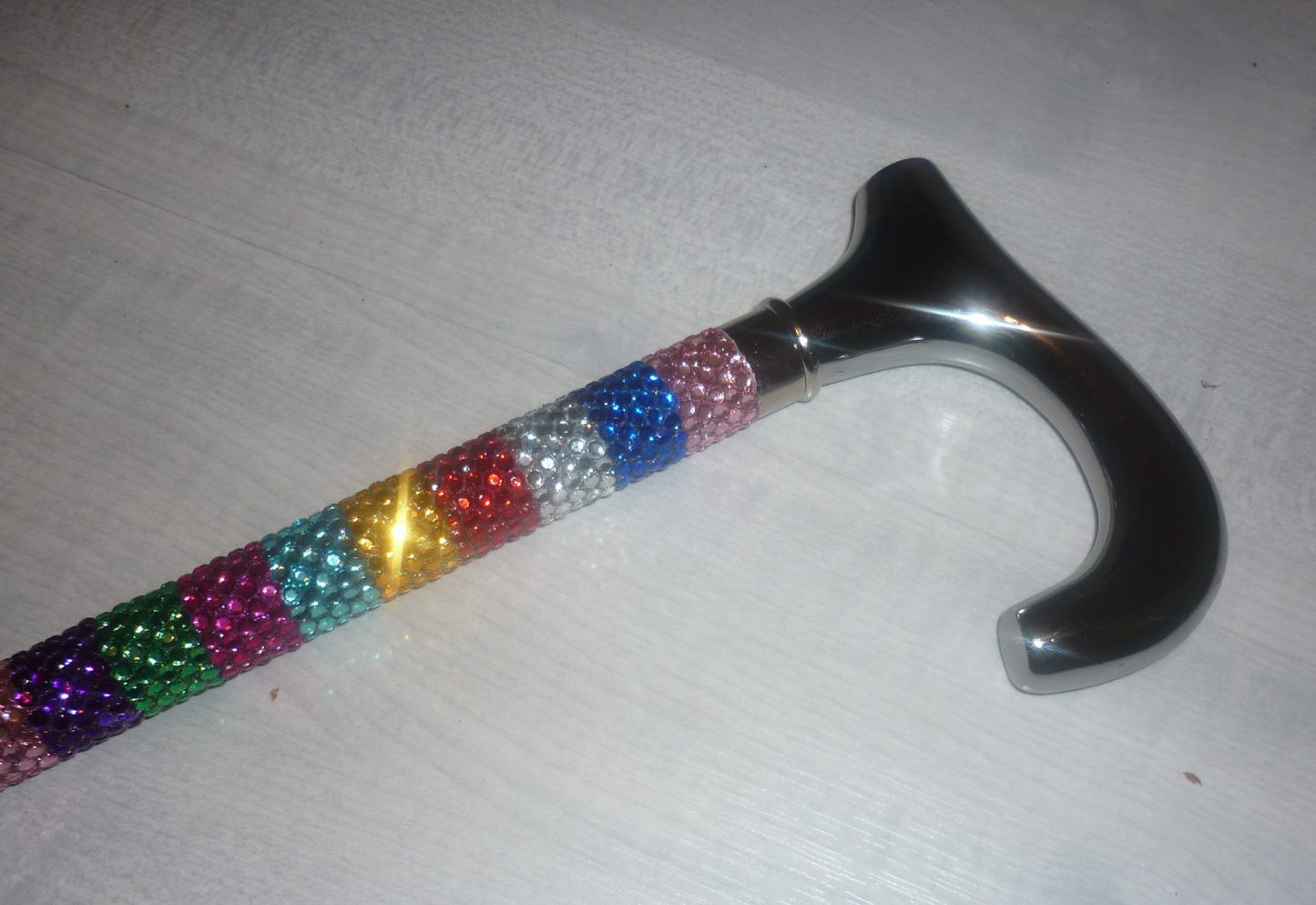 Lucy Sparkle Cane on reflective material showing a reflection. The cane has rows of colours Rhinestones down. 